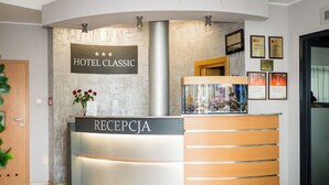 A hotel reception desk with a sign reading "HOTEL CLASSIC" and "RECEPCJA". - Hotel Classic (Rzeszów)