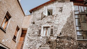 Ein Gebäude aus Stein mit mehreren Fenstern und einem Balkon.