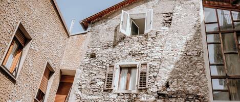 A stone building with multiple windows and a balcony.