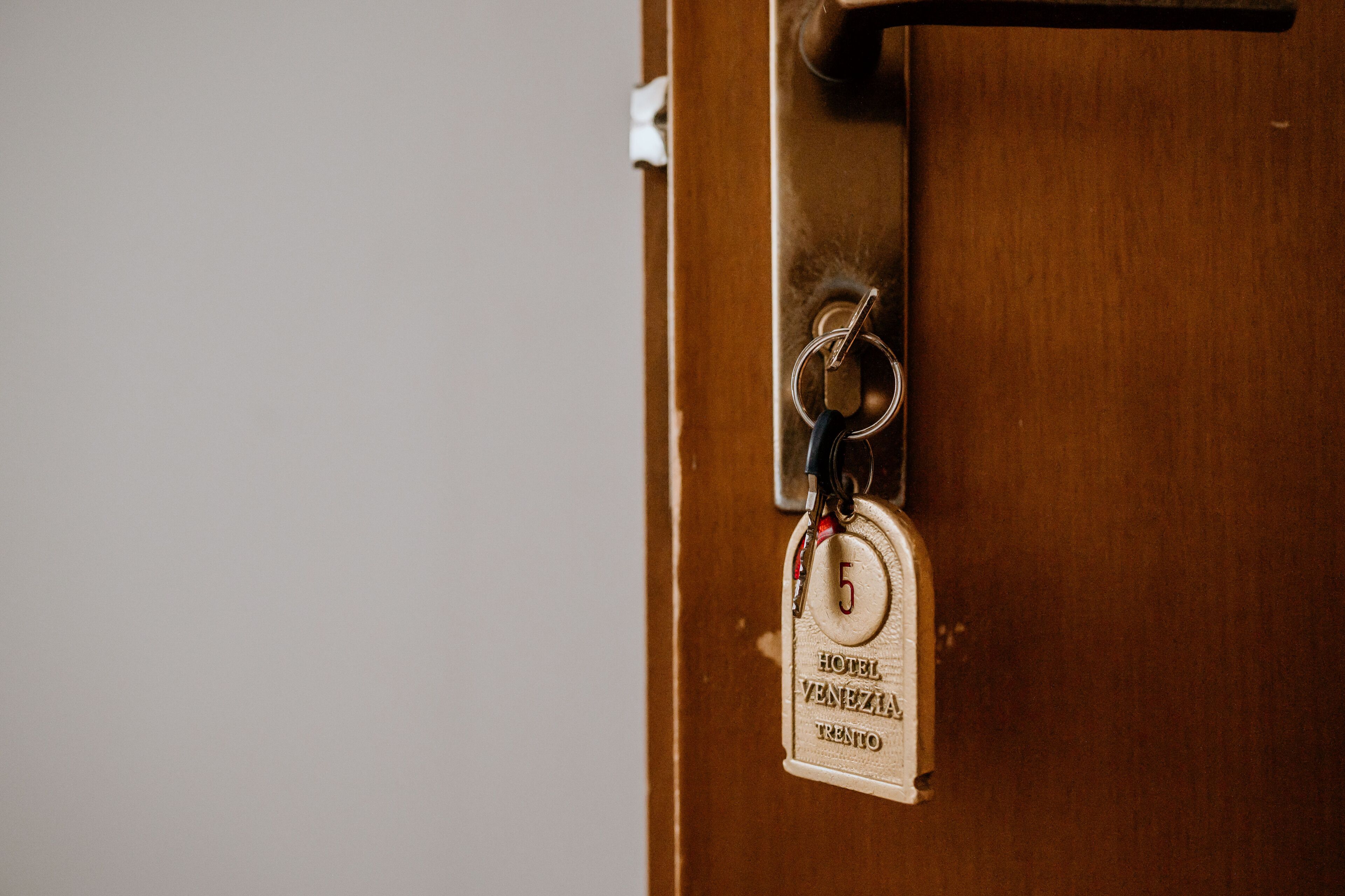 A keychain with a hotel name tag attached to a door handle.