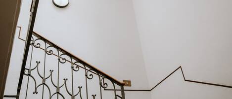 A staircase with a metal railing and a skylight above.