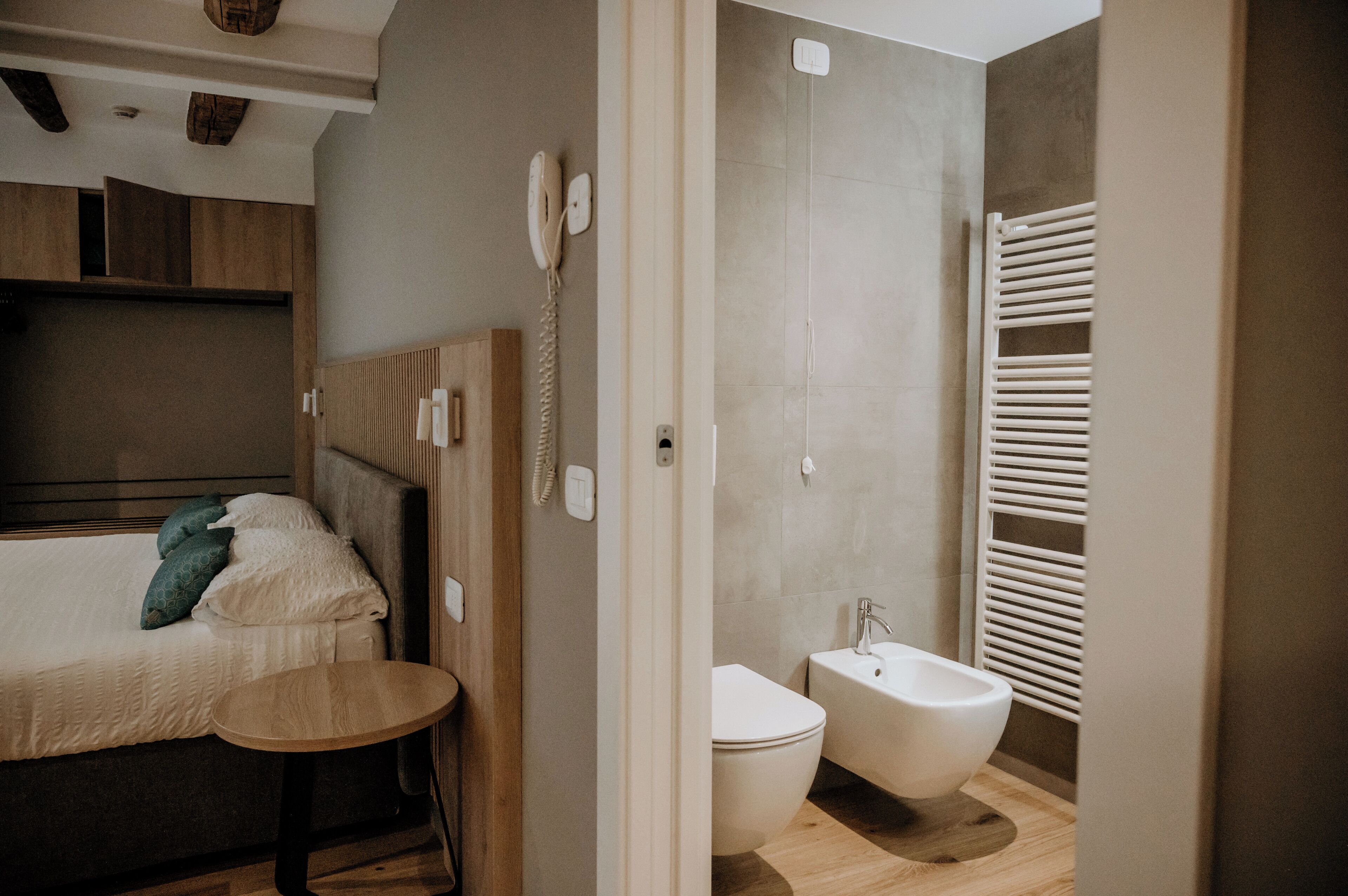 A modern bathroom with a toilet, bidet, and towel rack.