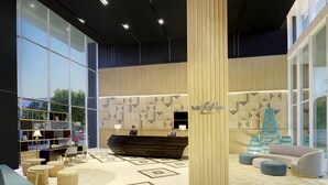A modern hotel lobby with a reception desk, seating area, and large windows offering views of the outdoors.