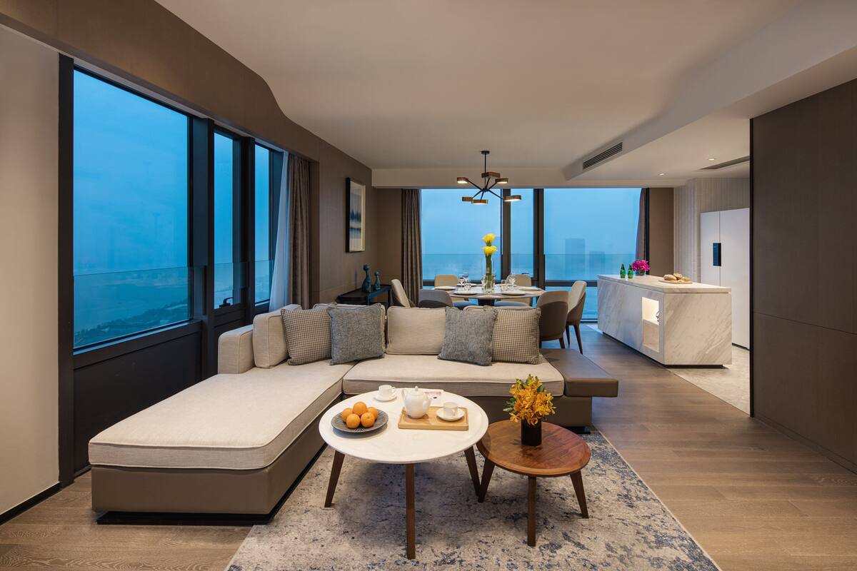 Un salon moderne avec un canapé, une table basse et une vue sur l’océan.