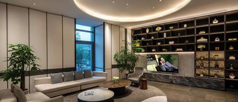 Un salon moderne avec un canapé, une table basse et un téléviseur.