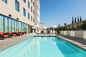 Una piscina al aire libre, sillones reclinables de piscina