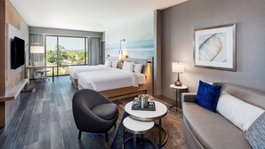 A hotel room with a bed, a sofa, a TV, a desk, and a view of the outdoors. - Courtyard by Marriott Los Angeles Monterey Park (Monterey Park)