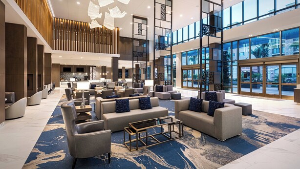 A spacious lobby with modern furniture, a large seating area, and large windows offering views of the outside. - Courtyard by Marriott Los Angeles Monterey Park (Monterey Park)
