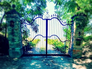 A gated entrance with a stone wall and a metal gate. - Galluzzo Ancient Country Villa (Casalecchio di Reno)