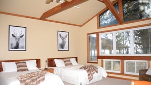 A room with two beds, wooden beams, large windows, and deer artwork on the walls. - Bent Mountain Lodge (Copper Hill)