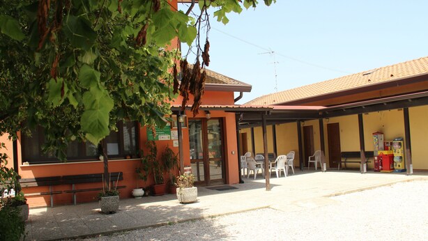 Un bâtiment doté d’un patio couvert, d’un espace extérieur aménagé pour s’asseoir et de plantes en pot.