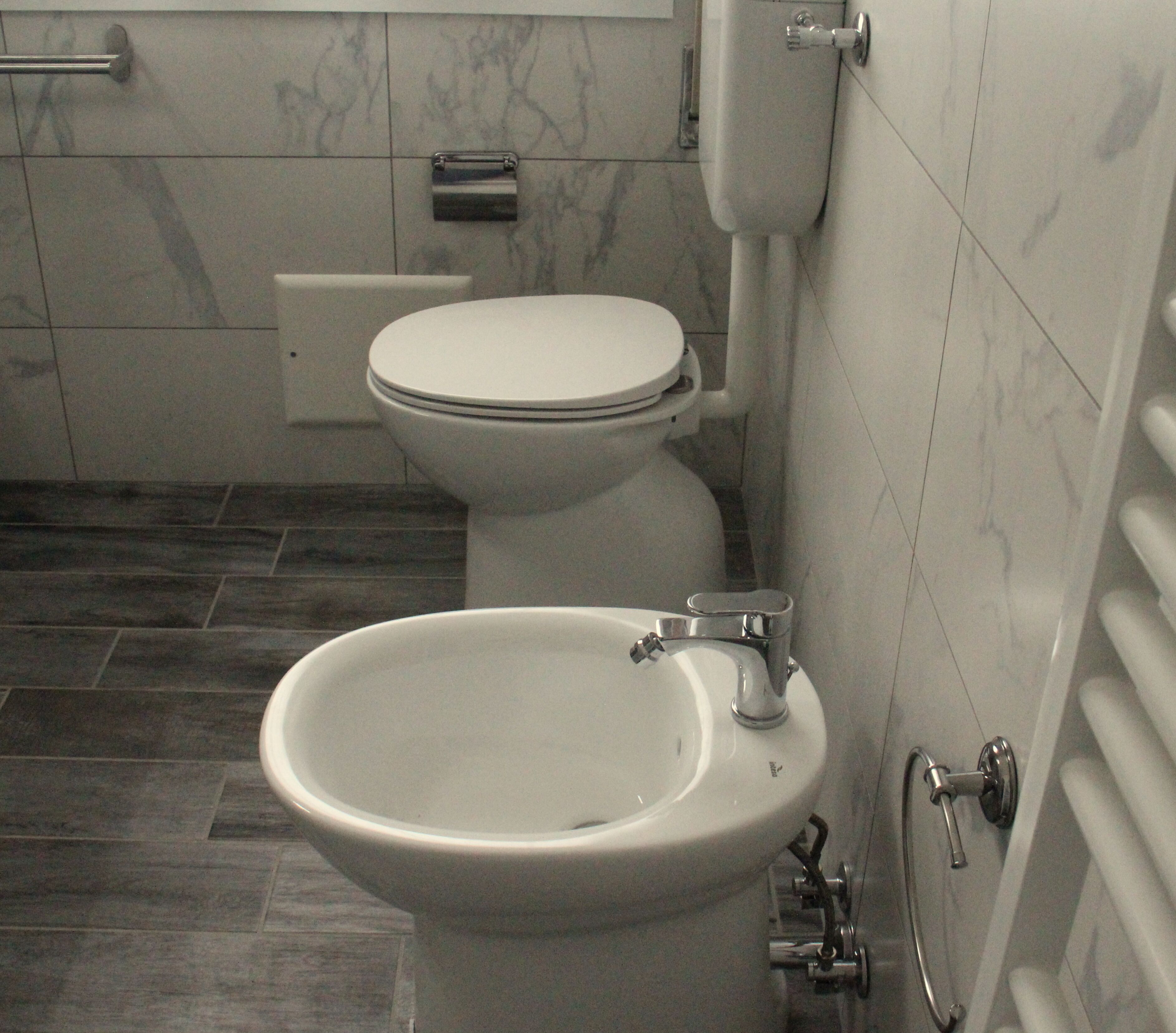 Un baño con inodoro, bidé y lavamanos.