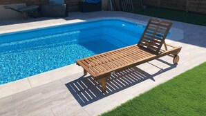 A swimming pool with a wooden lounge chair and a small garden area. - VUT Rural Dulcinea de la Mancha Pool Wifi (Fernán Caballero)