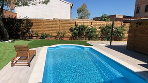 A rectangular swimming pool with a wooden deck and a lounge chair. - VUT Rural Dulcinea de la Mancha Pool Wifi (Fernán Caballero)