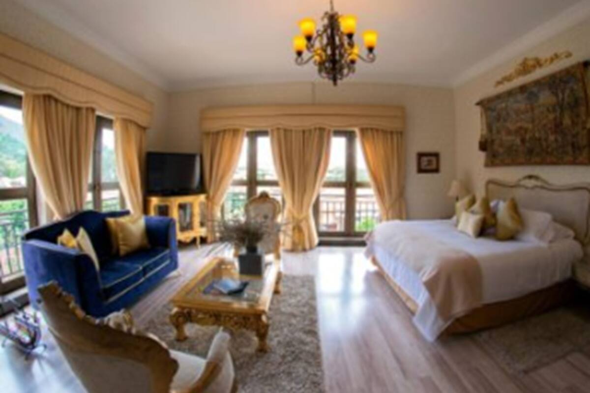 Ein Schlafzimmer mit einem großen Bett, einem Schlafsofa, einem Couchtisch und einem Fernseher.