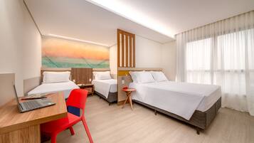 Habitación de hotel con dos camas, un escritorio, una silla y un cuadro en la pared.