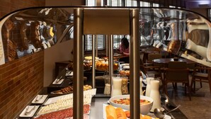 Un bufé con diversas opciones de comida, incluyendo carnes, frutas y postres.