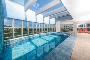 Una piscina techada, sillones reclinables de piscina