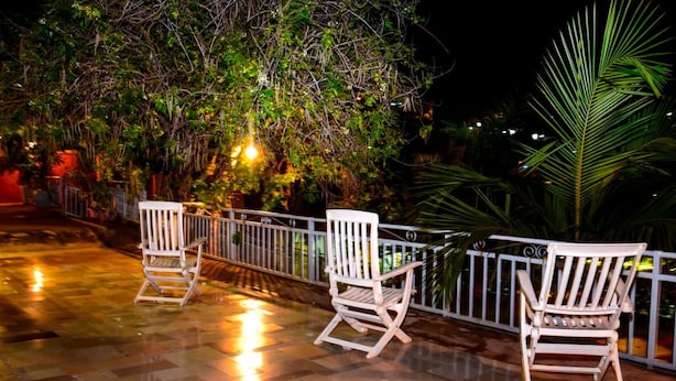 A patio area with tiled flooring and white chairs. - Zebra Tourism  Hotel (Kigali)