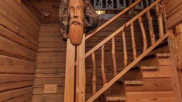 Eine Holztreppe mit einem geschnitzten Holzkopf oben.