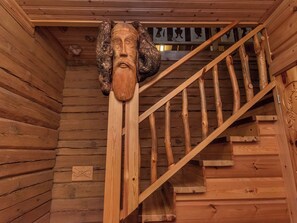 A wooden staircase with a carved wooden head at the top.