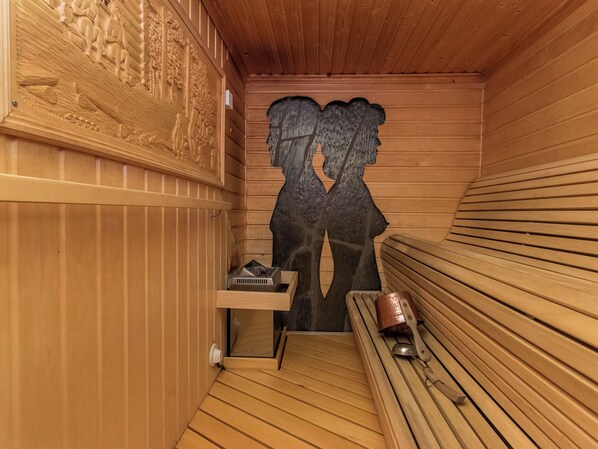 A sauna with wooden walls, a bench, and a bench heater.