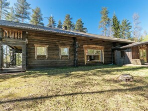 A rustic wooden cabin with a porch, large windows, and a chimney. - Villa kesäranta by Interhome (Kesälahti)
