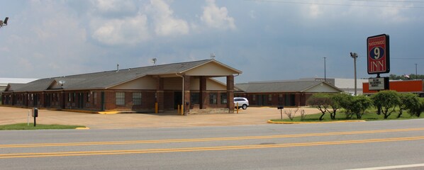 A motel with a covered parking area and a sign for a 9 Inn.