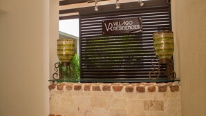 A brick fireplace with a sign for Villago Residences above it. - Villago Residences (Santo Domingo)