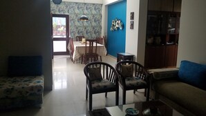 Una sala de estar con comedor, una pared azul de acento y un armario de madera.