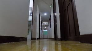 A long, narrow hallway with a shiny floor, leading to a door at the end. - Hotel Central - Mocoa (Mocoa)