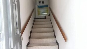 A staircase with a wooden handrail and a red carpet at the bottom. - Hotel Central - Mocoa (Mocoa)