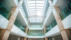 A multi-level atrium with glass railings and a central open space. - Grand Midway Hotel (Baku)