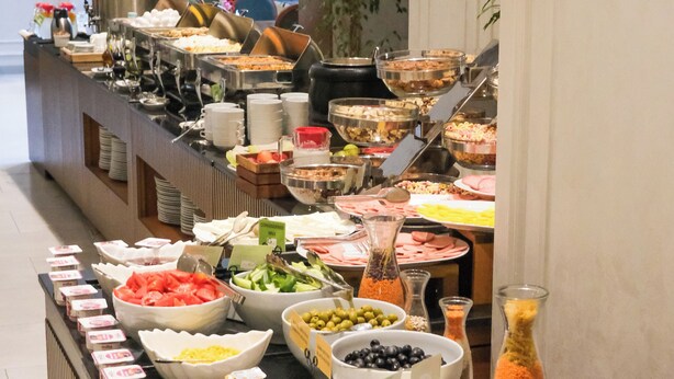 A buffet with various food items and condiments. - Grand Midway Hotel (Baku)
