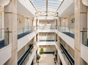 A multi-level atrium with glass railings, marble floors, and potted plants. - Grand Midway Hotel (Baku)