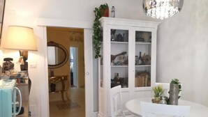 A dining area with a white table and chairs, a chandelier, and a cabinet with glass doors. - Borgo Salentino (San Vito dei Normanni)