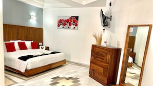 A modern bedroom with a bed, wooden headboard, a dresser, a mirror, and a wall-mounted TV. - Hotel Guadalajara Express (Tonalá)