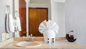 Um banheiro com pia, porta-toalhas e um vaso decorativo.