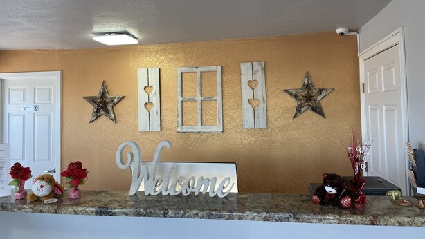 A kitchen counter with a 'Welcome' sign, decorative stars, and a window with shutters. - Hwy 59 Motel Laredo Medical Center (Laredo)
