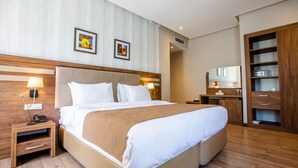 A hotel room with a large bed, wooden headboard, bedside tables, a wardrobe, and a mirror. - City Park Hotel Baku (Baku)
