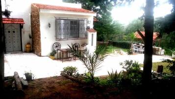 Una casa con un patio, un pequeño jardín y un comedor.