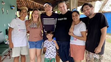 A group of people standing under a covered area with a tiled roof.