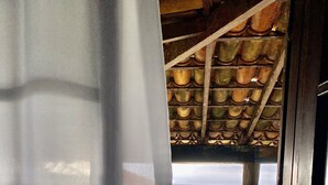 Een deuropening naar een balkon met uitzicht op zee en een blauwe constructie.