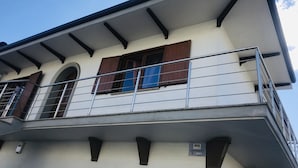 Ein Gebäude mit Balkon, einem Fenster mit braunen Rollläden und einem Schild, das dauerhafte Verbindung anzeigt.