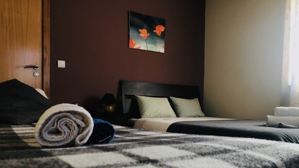 Ein Hotelzimmer mit Bett, Nachttisch, Lampe und einem Gemälde an der Wand.