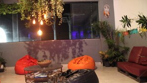 A modern living room with bean bags, a coffee table, and potted plants.