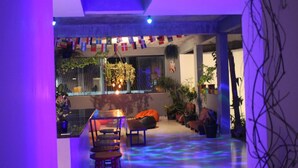A modern interior with a dining area, seating, and potted plants.