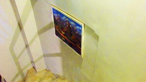 Un escalier avec une rampe et un tableau accroché au mur.