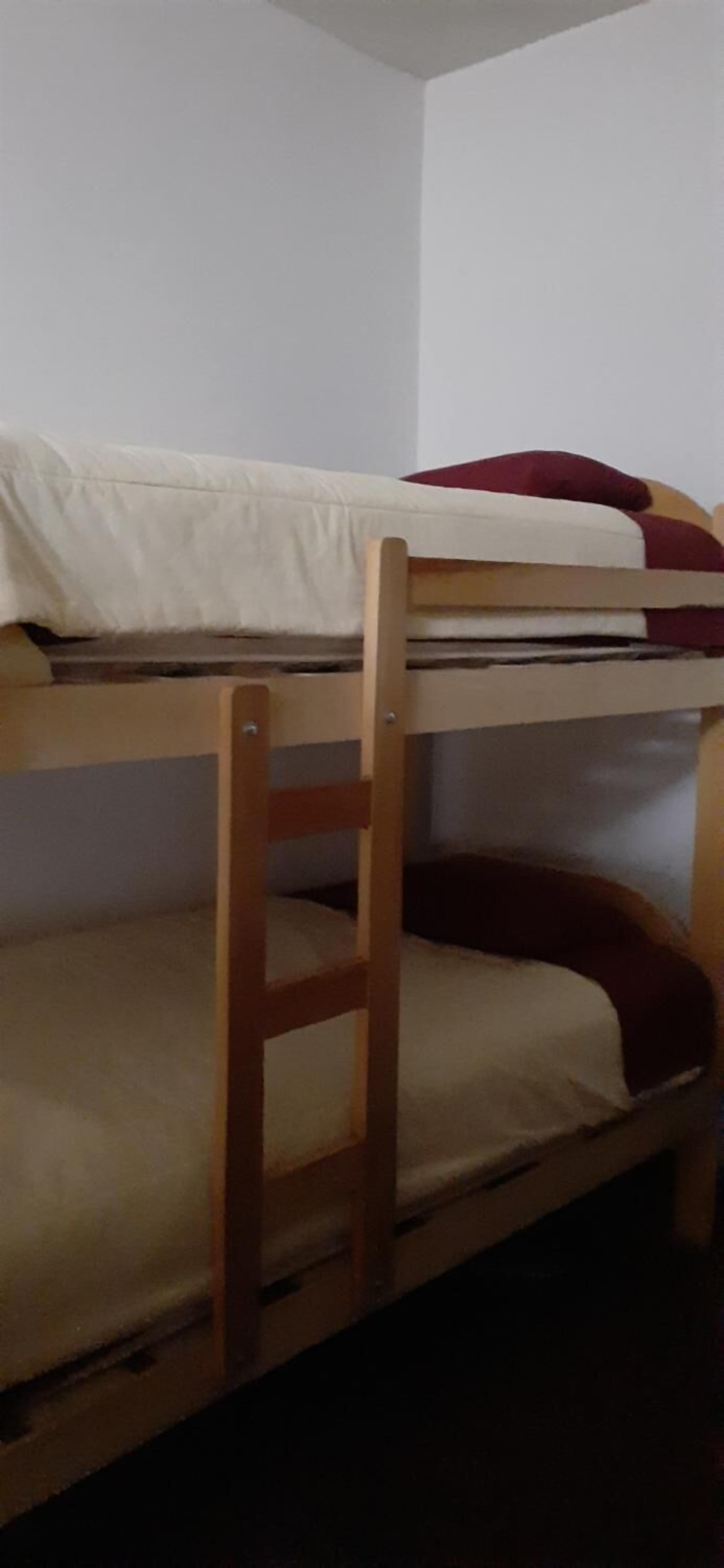 A bunk bed with a wooden frame and two levels of beds.