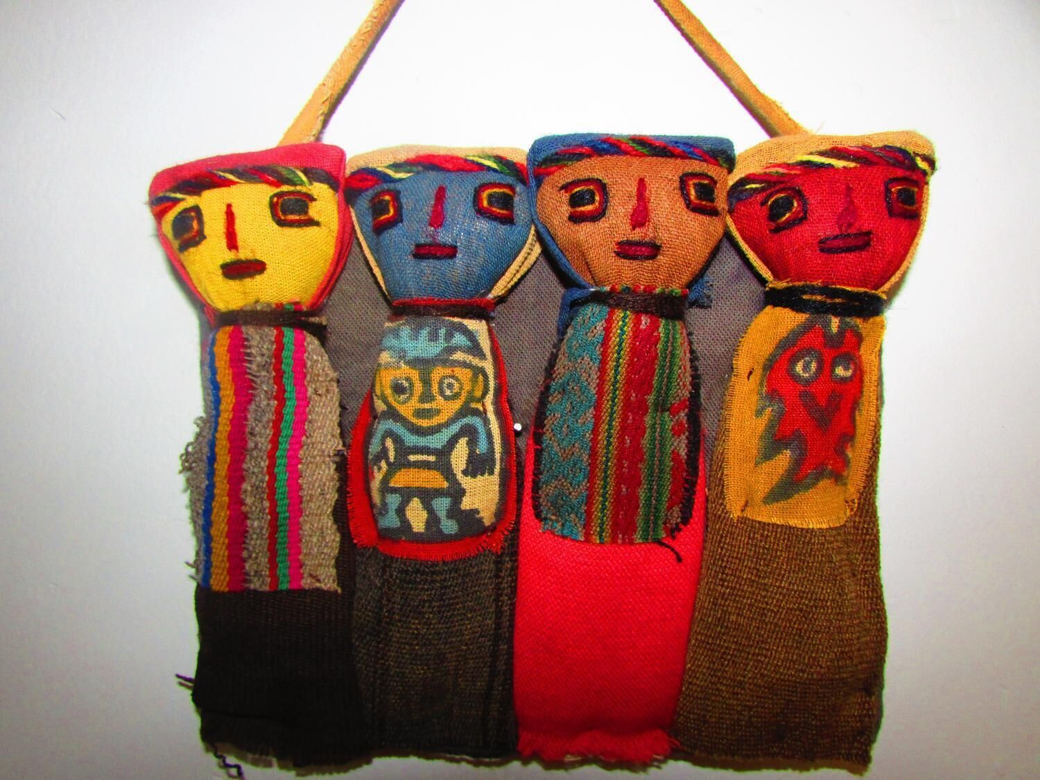 A collection of colorful, hand-stitched figures with distinct facial features and attire.